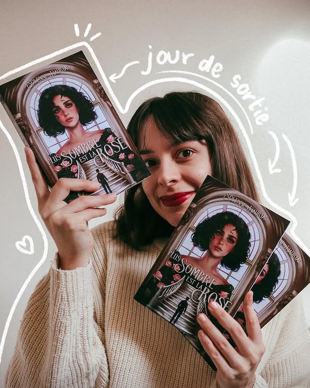 Solenne tient deux exemplaires de son roman « Plus sombre est la rose », annoté à la main « jour de sortie ».